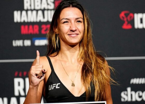 Amanda Ribas posa para fotos em cima da balança do UFC logo após bater o peso da divisão dos moscas