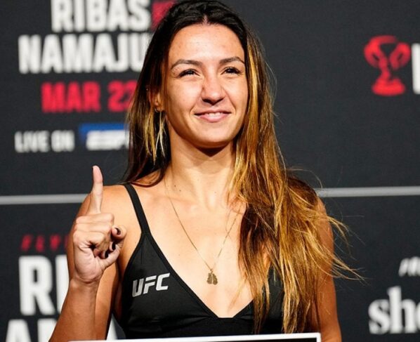 Amanda Ribas posa para fotos em cima da balança do UFC logo após bater o peso da divisão dos moscas