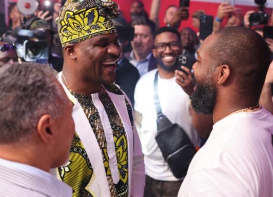 Francis Ngannou e Jon Jones se encaram de forma sorridente ao final da PFL Atlanta