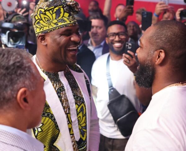 Francis Ngannou e Jon Jones se encaram de forma sorridente ao final da PFL Atlanta